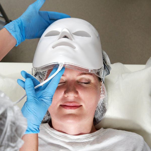 Client experiencing an LED facial device treatment at a medical spa